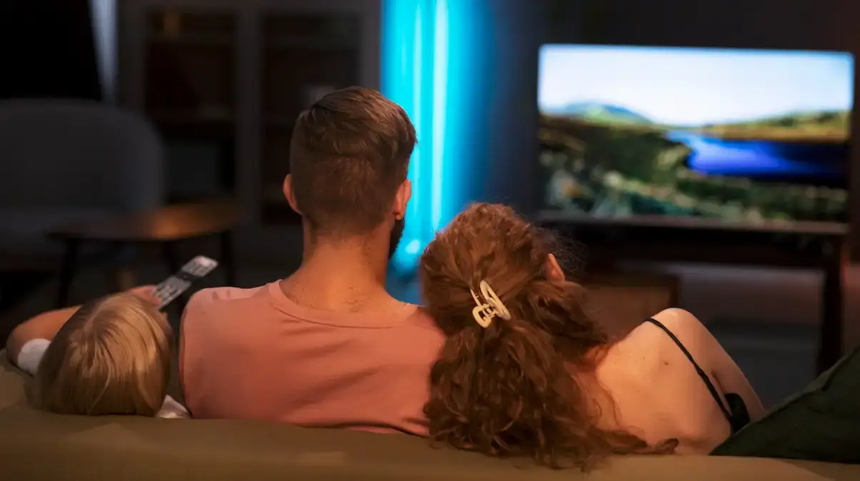 Photo of a family on a sofa watching a series