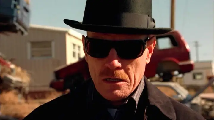 Walter White as his alter ego Heisenberg, wearing a black hat and sunglasses in the series Breaking Bad.